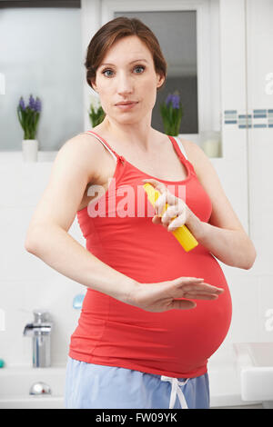 Pregnant Woman Spraying Mosquito Repellant To Protect Against Zika Virus Stock Photo