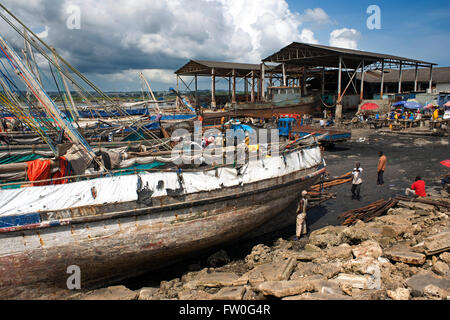 Hard workers working in the harbur of Stone Town, unloading traditional dhow in Zanzibar, Tanzania Stock Photo