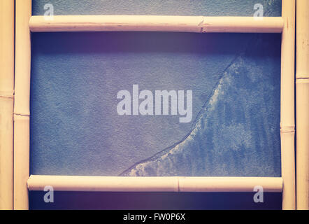 Vintage stylized bamboo frame with slate background with copy space. Stock Photo