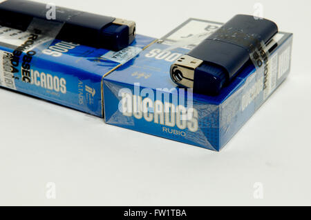 Two packets of Ducados cigarettes with lighters on white background Stock Photo