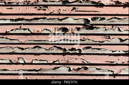 Paint peeling from an old weathered wooden wall of an old house Stock Photo