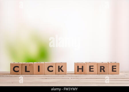 Click here message on a wooden table Stock Photo