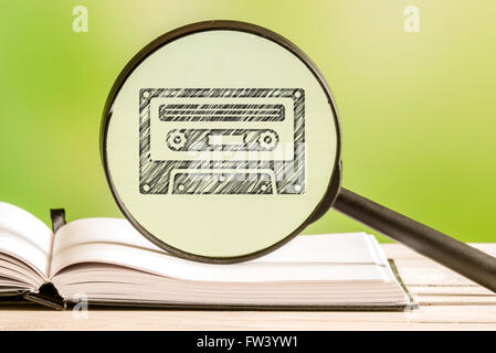 80s music information with a pencil drawing of a cassette tape in a magnifying glass Stock Photo