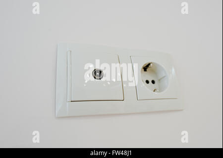 Twin electric socket with tv plug at the wall Stock Photo