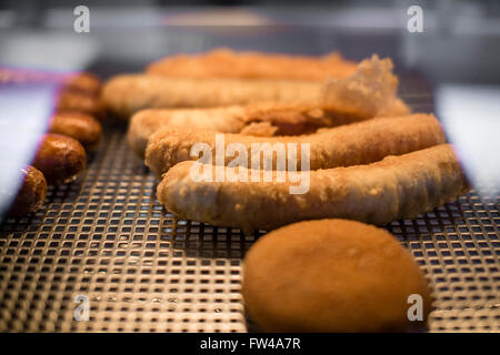 Fish & Chip shop in Cheltenham UK with a shelf of battered sausgaes. Stock Photo