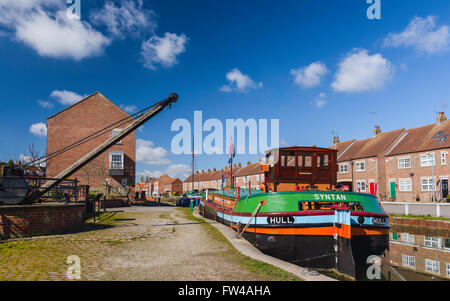 Restored barges, old winch, and town houses, along the beck (canal), with a view of the Minster on the horizon. Stock Photo