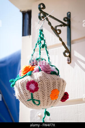 Yarn Bombing knitting graffiti in Bideford Devon, UK A knitted hanging basket Stock Photo