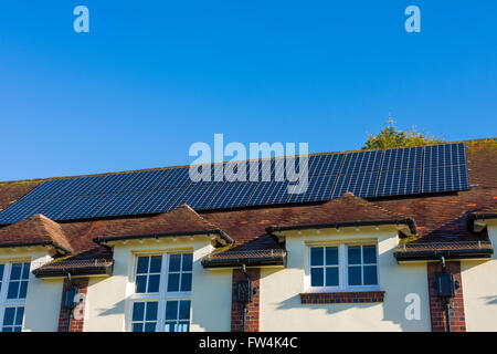 Photovoltaic solar panels on the roof of a village hall. Wrington, North Somerset, England. Stock Photo