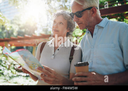 Close up portrait of senior couple using a map for directions. Retired couple exploring new places to visit during their vacatio Stock Photo