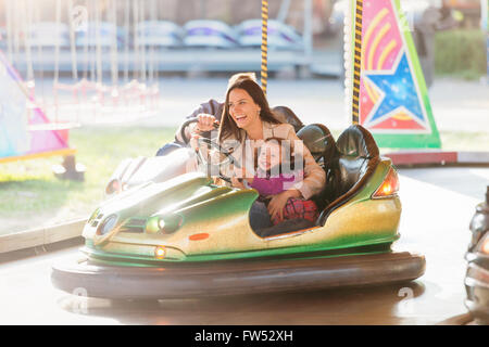 Mother and daughter in bumper car at fun fair Stock Photo