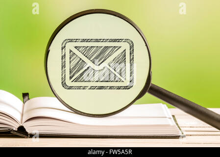 Mail search with a pencil drawing of a letter in a magnifying glass Stock Photo