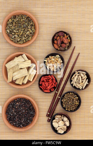 Chinese medicinal herb ingredients used in traditional herbal medicine over bamboo background. Stock Photo