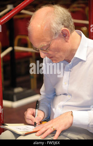 John Rutter, composer and editor, signing copies of the score before conducting his Requiem in the Royal Albert Hall with the Really Big Chorus, for Concerts from Scratch. Stock Photo