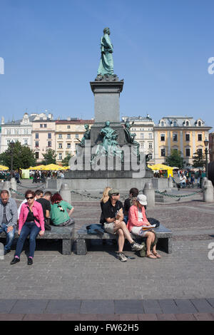 Poland, Krakow, Old Town Square, Adam Mickiewicz monument, tourists sitting on benches Stock Photo
