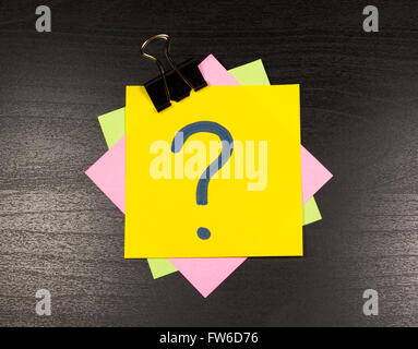 question mark on a sticky note on wooden background Stock Photo