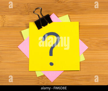 question mark on a sticky note on wooden background Stock Photo