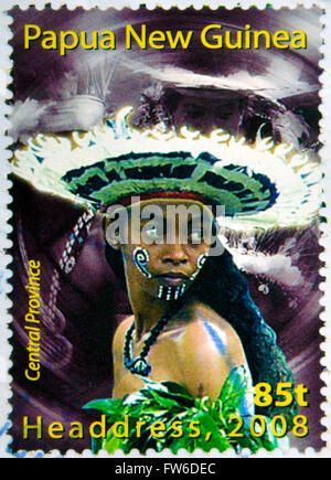 PAPUA NEW GUINEA - CIRCA 2000: Stamp printed in Papua New Guinea shows a woman in a feathered headdress Stock Photo