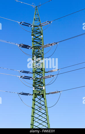 a high voltage power pylons against blue sky and sun rays Stock Photo