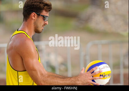 Volleyball player is a male beach volleyball player getting ready to serve the ball. Stock Photo