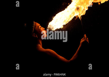 Fire breather is a female fire breather firing her flames in all it's fiery hot beauty. Stock Photo