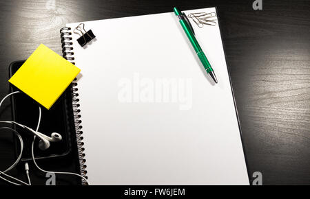 Notebook with blank paper, color sticky notes, pen and clips on a wooden table Stock Photo