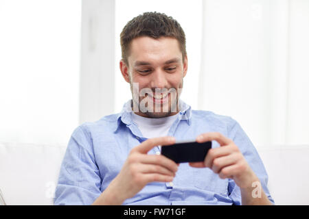 happy man with smartphone at home Stock Photo