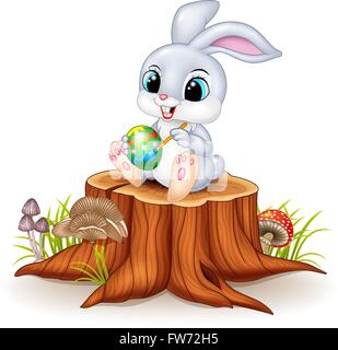 Cartoon Easter Bunny painting an egg on tree stump Stock Vector