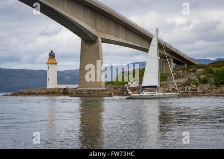 A Yacht passes underneath the Skye bridge on the way to the small harbour of Kyle of Lochalsh Stock Photo