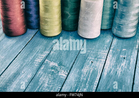 Vintage photo colored threads for sewing and embroidery on the wooden table Stock Photo