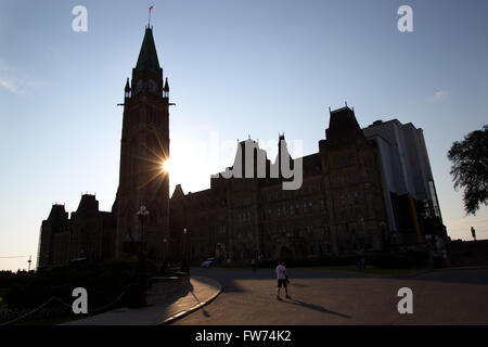 The sun sets behind the Peace Tower on centre block on Parliament Hill in Ottawa Ont., on Sunday Jul. 26, 2015. Stock Photo