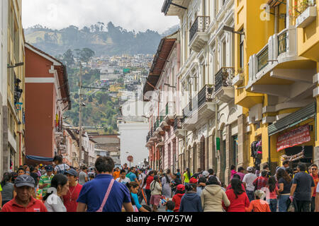 QUITO, ECUADOR, OCTOBER - 2015 - Crowded sidewalk with colonial style buildings and hill at background in the historic center of Stock Photo