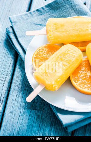 homemade refreshing popsicle with fresh orange slices, on wooden table Stock Photo