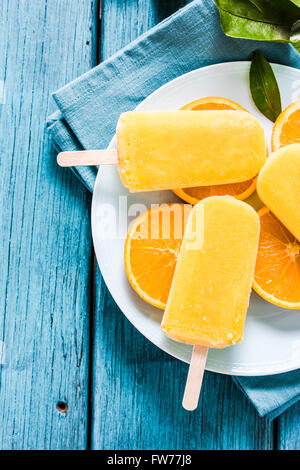 Healthy snack, orange natural popsicle on fresh fruit slices Stock Photo