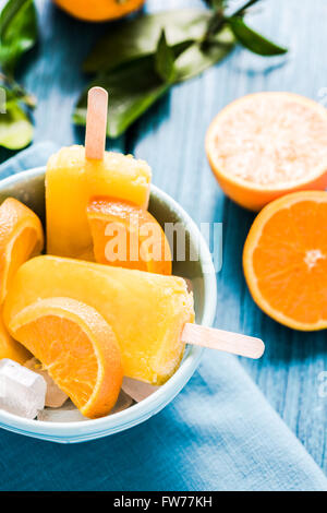 Homemade lilly pops in bowl with fruits, on wooden rustic table Stock Photo