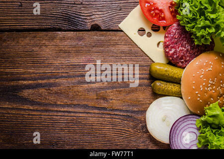 Ingredients for hamburgers on wooden table, border background with copy space for recipe or text. Stock Photo