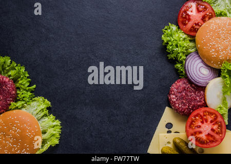 Dark restaurant menu, burger ingredients and copy space. Dark slate from above. Stock Photo