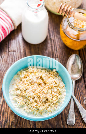 Healthy breakfast, porridge in bowl. Jar with honey in background Stock Photo