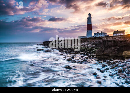 Time lapse sunset on coast with lighthouse on cliffs in Portland, Dorset, UK. Stock Photo