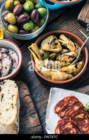 Sharing authentic spanish tapas with friends in restaurant or bar. View from above. Stock Photo