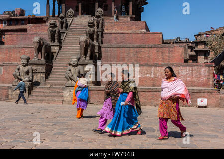 Bhaktapur, Nepal.  Women Crossing Taumadhi Tole Square.  Rajput Wrestler-guardians Jayamel and Phattu Guard Stairs to temple. Stock Photo