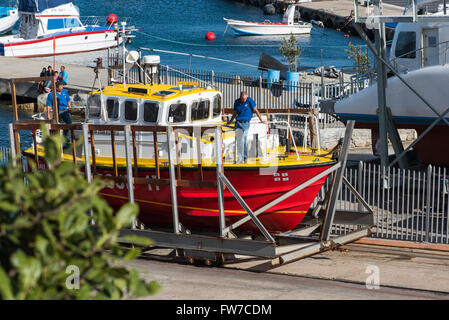 A NSRI boat being pulled up out of the water at the harbour in Hermanus Stock Photo