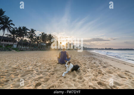 Young Woman Practicing Yoga on the Beach in Hikkaduwa Stock Photo