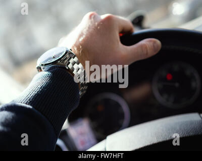 Close-up of man's hand on steering wheel. Shallow depth of field. Stock Photo