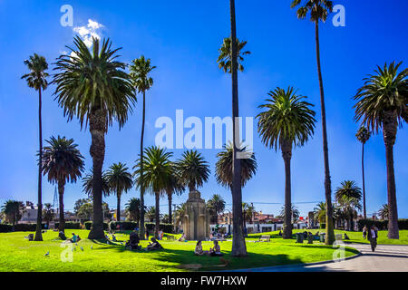 People picnicking and enjoying relaxing on a hot sunny day, O'Donnell Gardens, a City park, next to Luna Park, St Kilda, Melbourne Australia Stock Photo