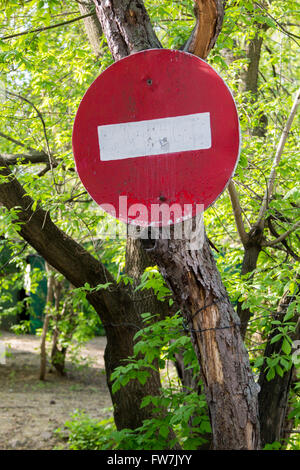 old 'do not enter' sign with peeling paint on a tree Stock Photo