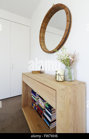 Interior decoration styling of wooden sideboard buffet and mirror with candle and vase of flowers Stock Photo