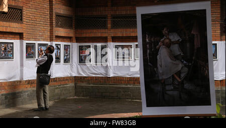 Kathmandu, Nepal. 31st Mar, 2016. A man takes photos at the photo exhibition 'PhotoNepal' showcasing photos of the country by Chinese photographer Tang Yuefan at Nepal Tourism Board (NTB) in Kathmandu, Nepal, March 31, 2016. The NTB organizes photo exhibitions every month to promote the country's tourism industry through photos. © Sunil Sharma/Xinhua/Alamy Live News Stock Photo