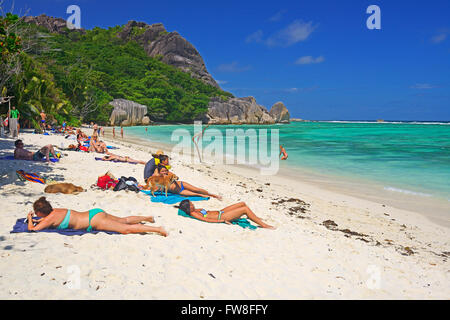 Badegaeste sonnen sich am Traumstrand Source d'Argent, Insel La Digue, Seychellen Stock Photo