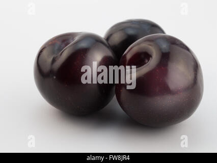Photo of three plums on white background focus on front plum Stock Photo