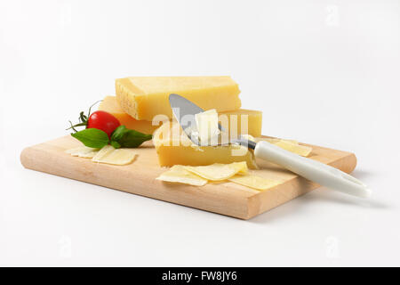 parmesan cheese and cheese knife on wooden cutting board Stock Photo